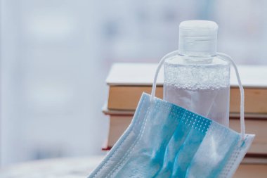 Masada kitaplar, tıbbi maske ve hidrokolik jel, kapalı alanlarda yeni normal koruma kavramı