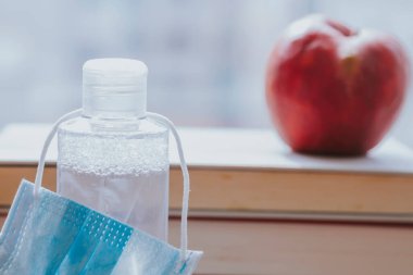 Kitap, elma ve tıbbi maske. Okul konseptine geri dönelim.