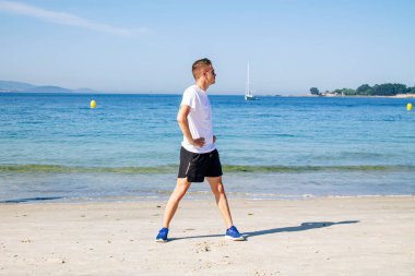 Genç adam plajda spor yapıyor. Rahatlamak için.