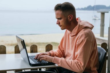 genç adam açık havada dizüstü kullanarak