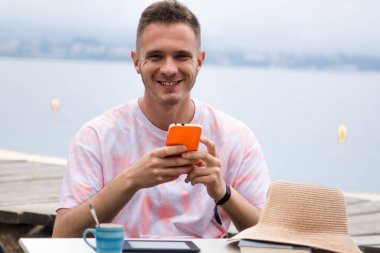 Genç adam dışarıda cep telefonu kullanıyor.