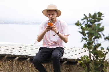 Genç adam dışarıda akıllı telefon kullanıyor.