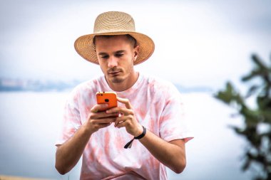 Genç adam dışarıda akıllı telefon kullanıyor.