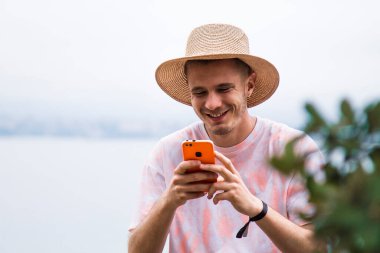 Genç adam dışarıda akıllı telefon kullanıyor.