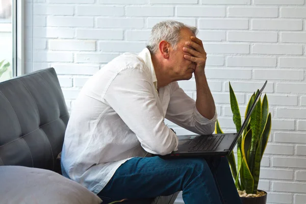 Ofisinde ya da iş yerinde bilgisayarından rahatsız ve bunalmış bir adam.