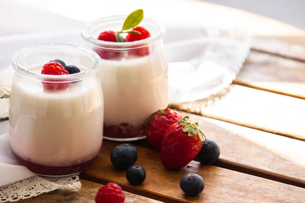 Ahşap arka planda yabanmersinli yoğurt.