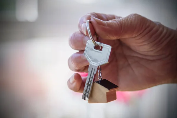 手持钥匙链 带有小房子和钥匙 抵押概念 房地产 — 图库照片