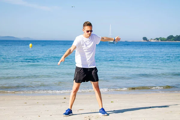 Genç adam plajda spor yapıyor. Rahatlamak için.
