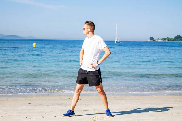 Genç adam plajda spor yapıyor.