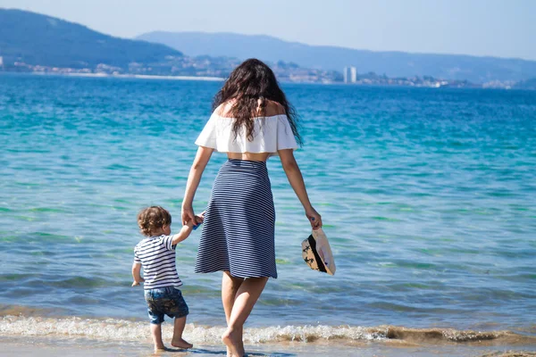 Anne ve çocuk sahilde yürüyor.