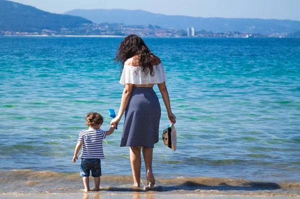 Anne ve çocuk sahilde yürüyor.