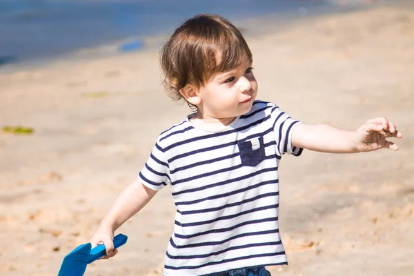 ビーチでシャベルとバケツで遊んでいる男の子 — ストック写真