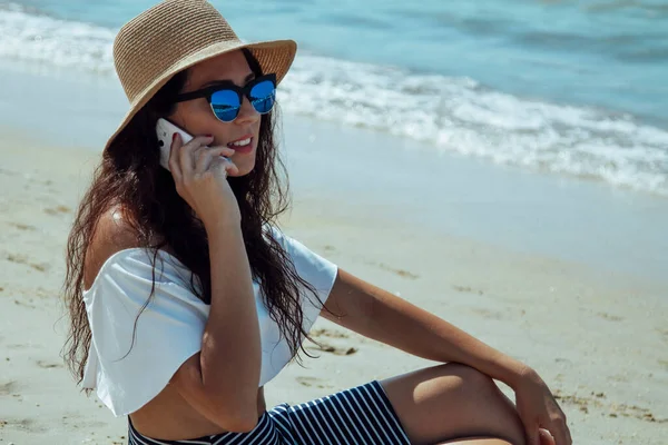 Žena Klobouku Mluví Mobilním Telefonem Sedí Pláži — Stock fotografie