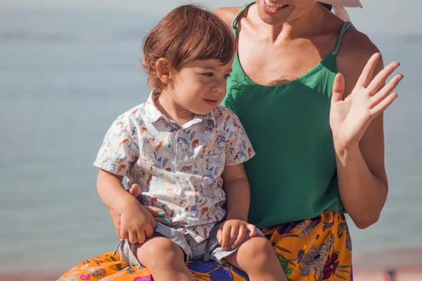 Küçük çocuk ve annesi el sallıyor.