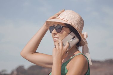 Mobil telefonda konuşurken şapkalı kadın