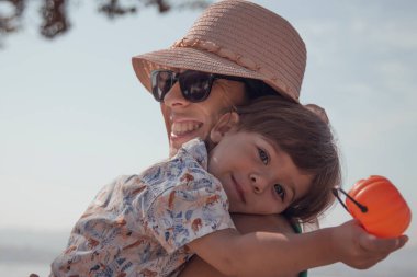 Çocuk annesiyle birlikte bir balkabağıyla oynuyor.