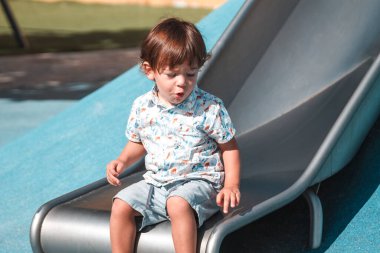 Küçük çocuk park kayağında oynuyor.