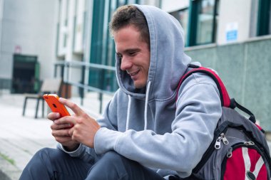 Lisede cep telefonu kullanan genç bir öğrenci.