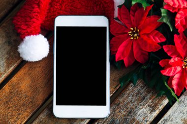 Noel süslemeleri ile ahşap üzerinde cep telefonu