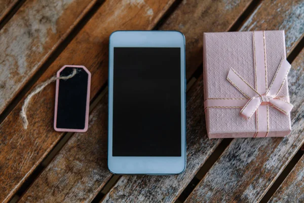Telepon Seluler Pada Kayu Dengan Kotak Hadiah Dan Tag — Stok Foto