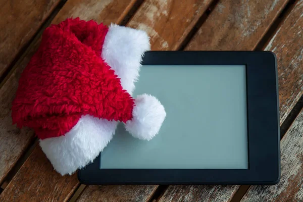 Digitale Tablet Met Kerstman Hoed Houten Achtergrond — Stockfoto