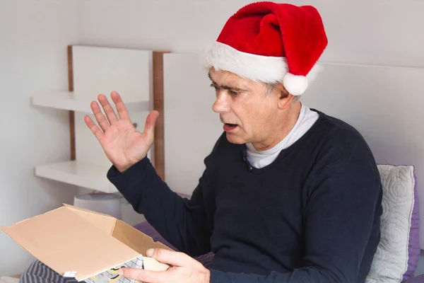 Mann Mit Weihnachtsmann Hut Erstaunt Und Glücklich Über Sein Weihnachtsgeschenk — Stockfoto