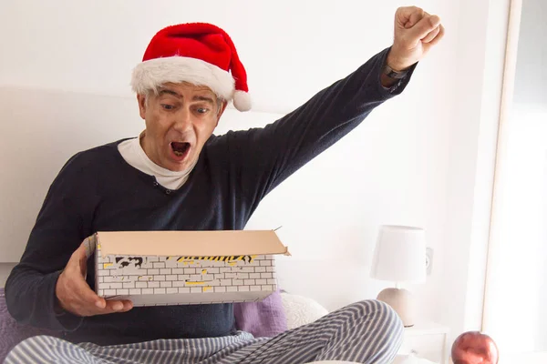 Mann Mit Weihnachtsmann Hut Erstaunt Und Glücklich Über Sein Weihnachtsgeschenk — Stockfoto
