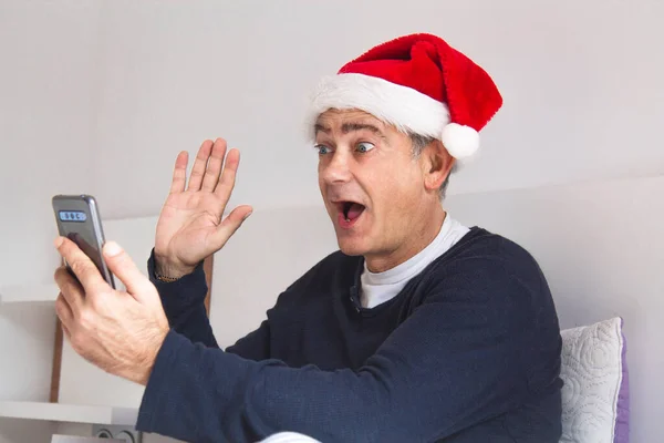 Attraktiver Reifer Mann Mit Weihnachtsmütze Und Handy Beim Videoanruf — Stockfoto