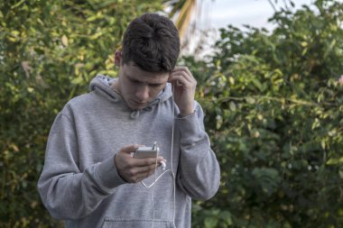 Üzgün genç adam, kulaklıkla mesajı dinliyor.