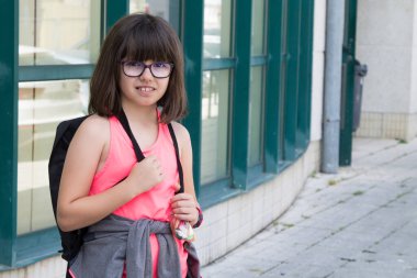 Okul kapısında sırt çantalı bir öğrenci, okul konseptine geri dönüyor.