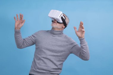 3D sanal gerçeklik gözlüklü adam mavi arka planda izole edilmiş.