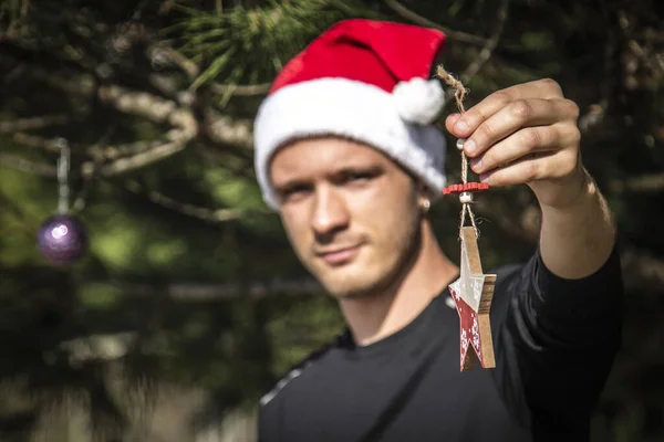 Junger Mann Mit Weihnachtsmann Mütze Der Weihnachtsschmuck Weihnachtsbaum Platziert — Stockfoto