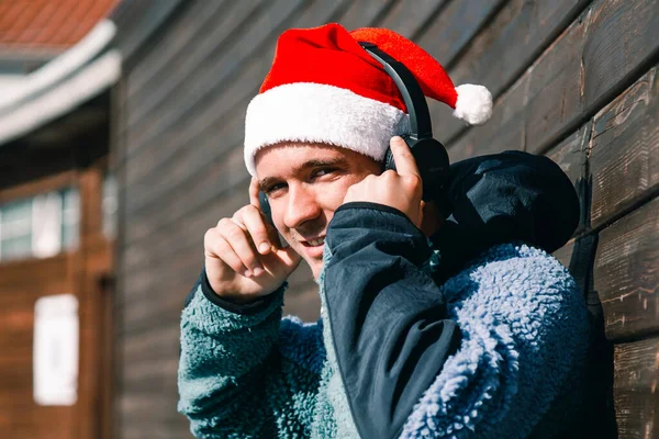 Χαλαρός Άνθρωπος Χριστουγεννιάτικο Καπέλο Και Ακουστικά Ακούγοντας Μουσική — Φωτογραφία Αρχείου