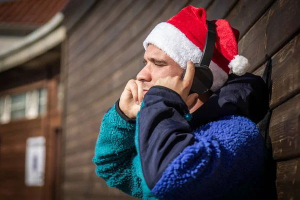 Χαλαρός Άνθρωπος Χριστουγεννιάτικο Καπέλο Και Ακουστικά Ακούγοντας Μουσική — Φωτογραφία Αρχείου