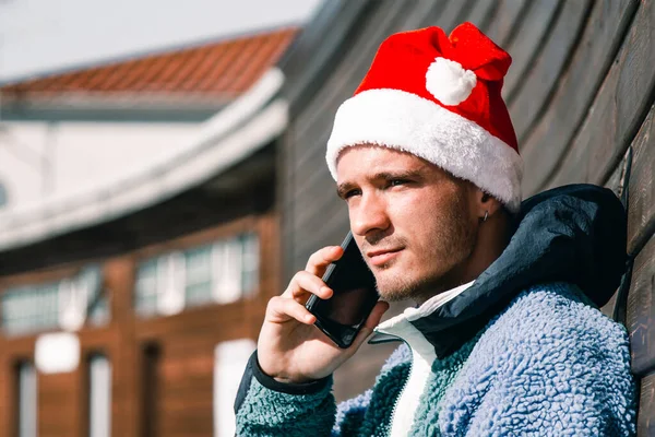 Mann Mit Weihnachtsmannmütze Gespräch Mit Seinem Handy — Stockfoto