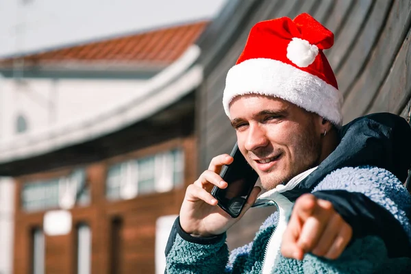 Mann Mit Weihnachtsmütze Telefoniert Und Zeigt — Stockfoto