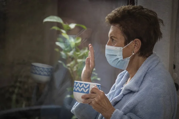 Сумна Депресивна Самотня Старша Жінка Медичною Маскою Пандемії Махає Вікна — стокове фото