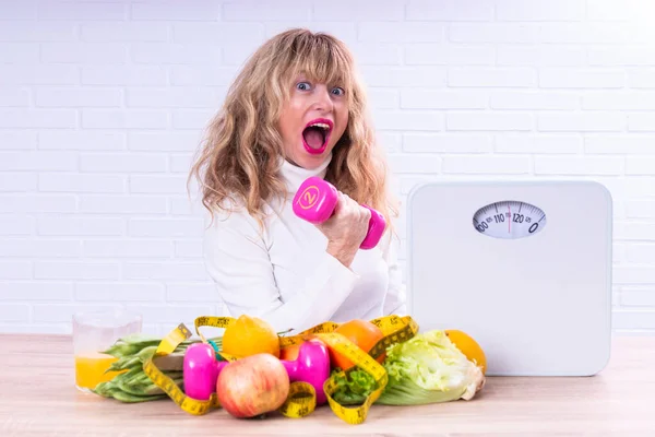 happy successful diet woman with dumbbells, scale and vegetables