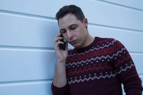 Atraktivní Mladý Muž Mluví Mobilním Telefonem Bílé Stěně — Stock fotografie