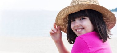 Plajdaki şapkalı kızın portresi.