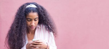 Cep telefonunu kullanan Afrikalı Amerikalı bir kız.