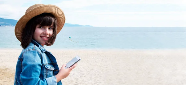 Дівчина Капелюсі Джинсовій Куртці Використовуючи Мобільний Телефон Пляжі — стокове фото