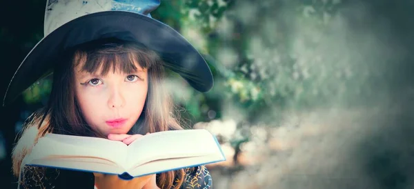 witch girl on halloween making spells with magic book of spells, happy halloween party