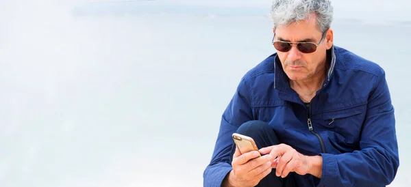 해변에서 핸드폰을 사용하는 — 스톡 사진