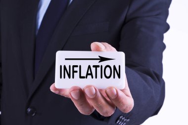 İş adamı elinde enflasyon grafiği ve okuyla pankart tutuyor