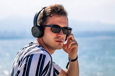 Sahilde kulaklıklı bir adam rahatladı.