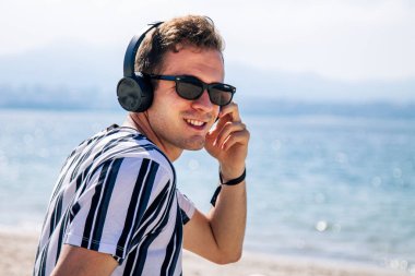 Sahilde kulaklıklı bir adam rahatladı.