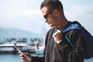 Sırt çantalı genç adam seyahat haritasına bakıyor.