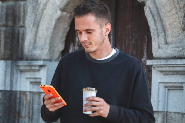 Delikanlı cep telefonunu kontrol ediyor.