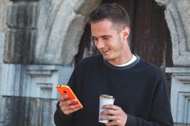 Delikanlı cep telefonunu kontrol ediyor.